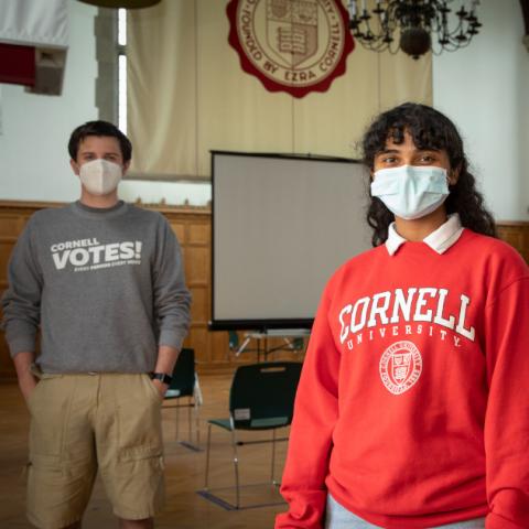 Three students from Cornell Votes stand in Willard Straight Hall Memorial Room