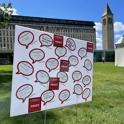 Poster board with hazing prevention messages written on it placed in front of McGraw Tower