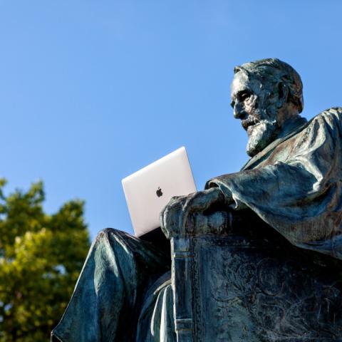 AD White statue with laptop sitting in lap