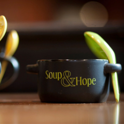 Black Soup and Hope bowl with green spoon
