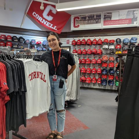Ella Hsu '25 stands amidst inventory at the Cornell Store where she works.
