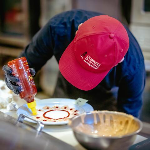 Cornell Dining team member plates a dish as part of a training session