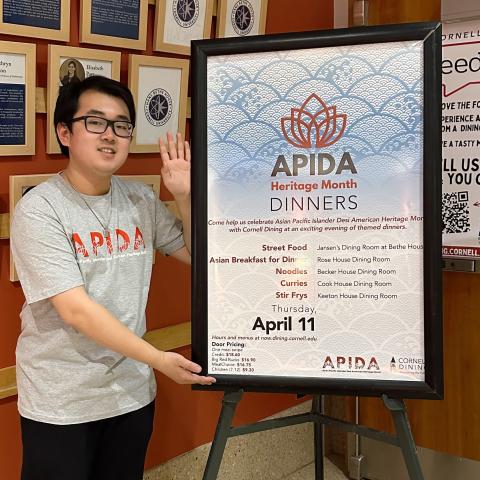 Jason Xiong '25 in front of an APIDA Heritage Month promotional sign.