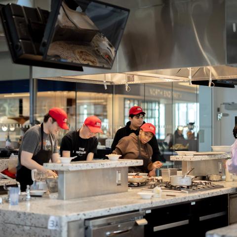 Students cook in a shared teaching kitchen