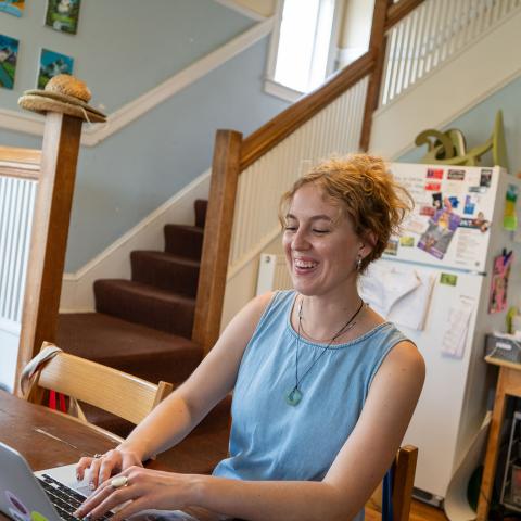 Julia Dahl sits at a desk with her laptop