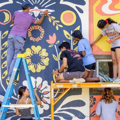 Students participate in a community paint event at Wildflower Farm in Enfield.