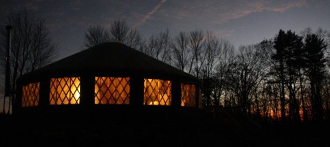 A yurt on the chalenge course is lit by the fire within
