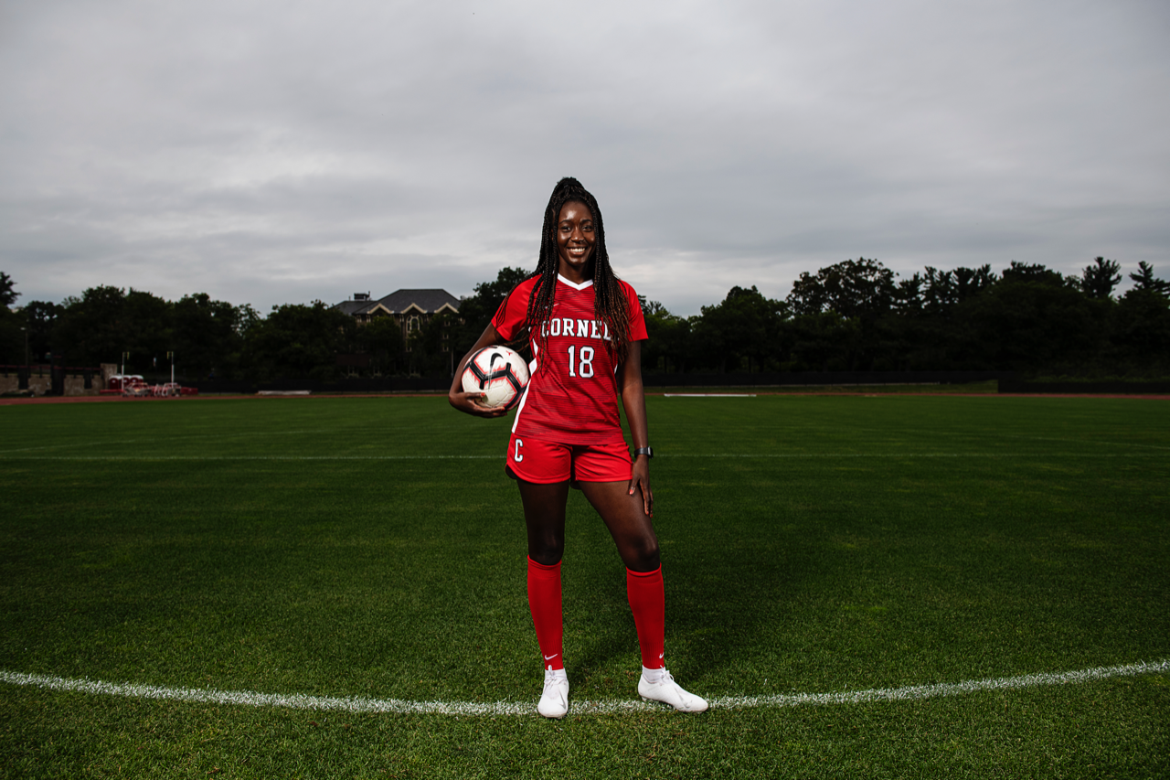 Cornell Women's Soccer team member Mofoluke Obiri '22 poses on the field with a soccer ball.