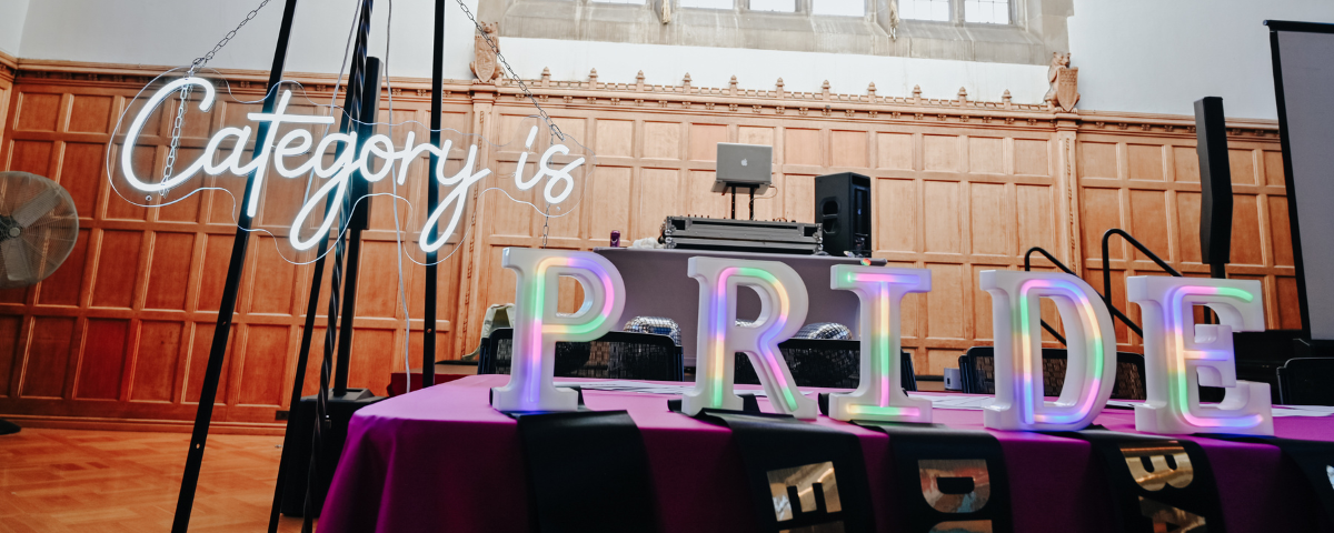 A tabletop "PRIDE" sign at prom.