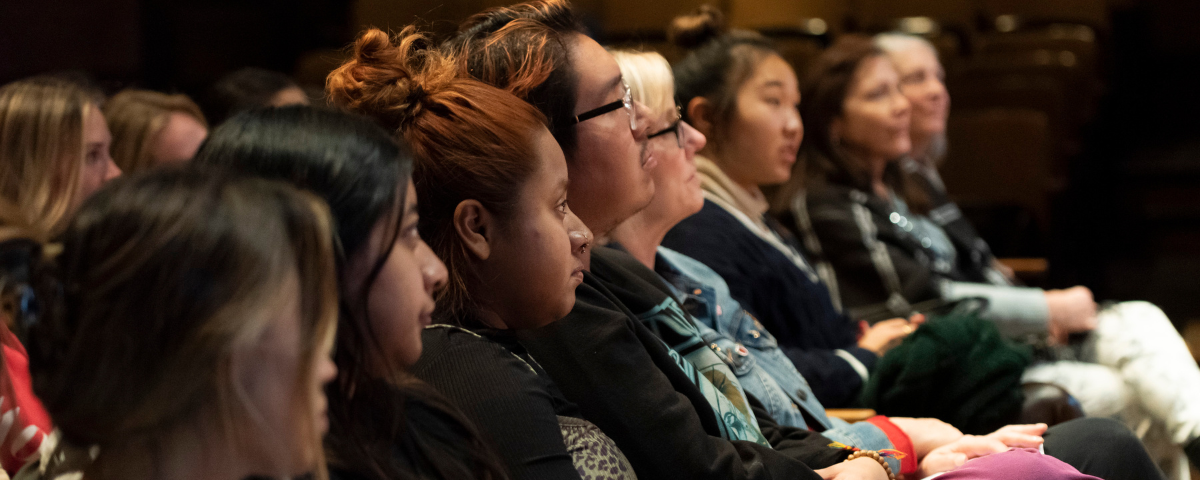 Audience members listen to a speaker