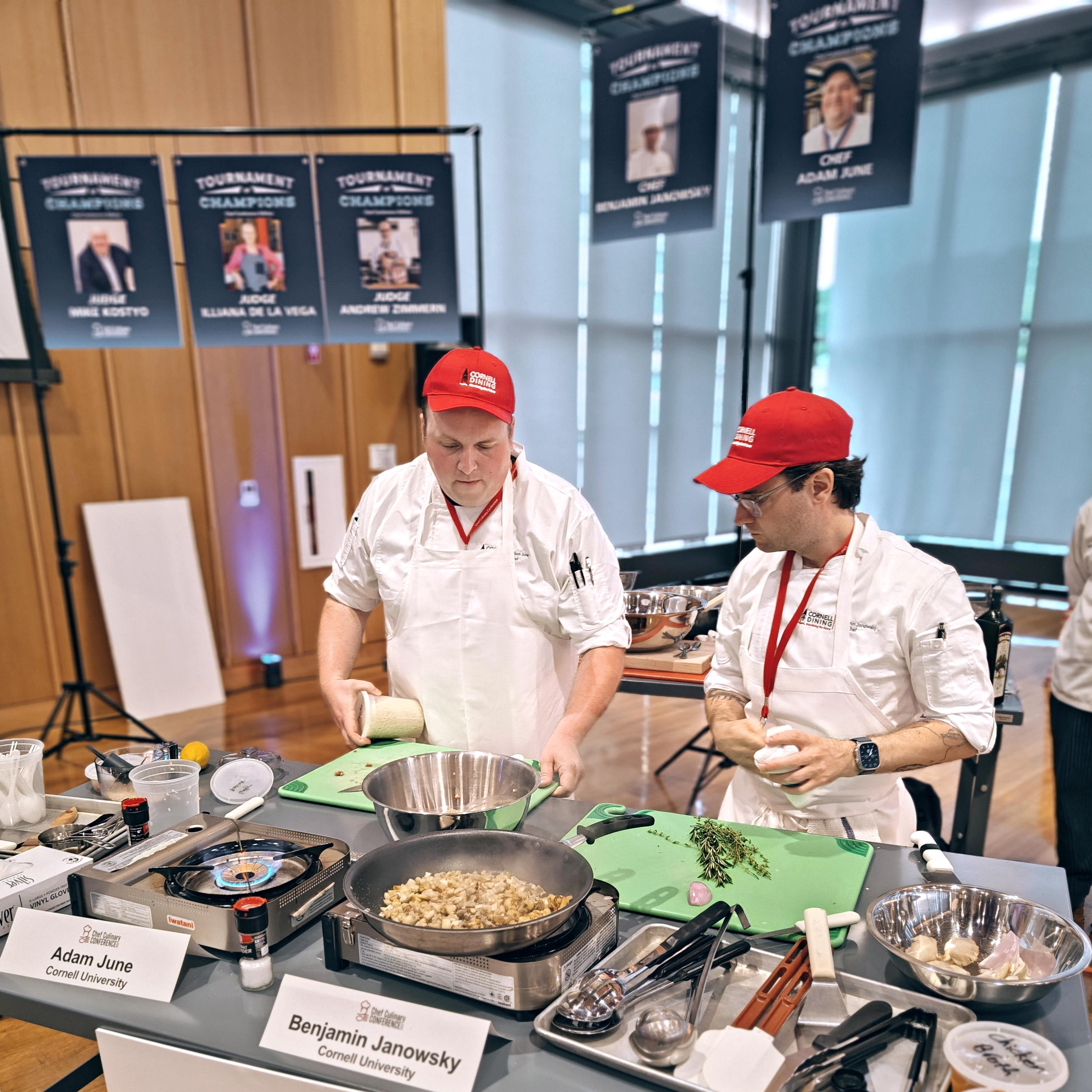 Chefs Adam June and Benjamin Janowsky at a workstation with food and utensils