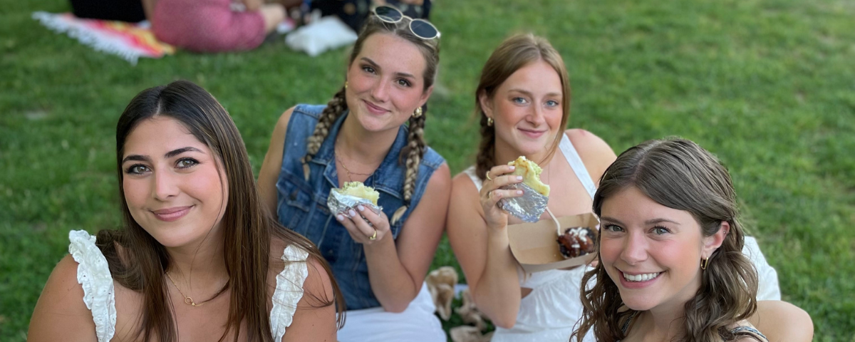 Women sitting in the grass eating