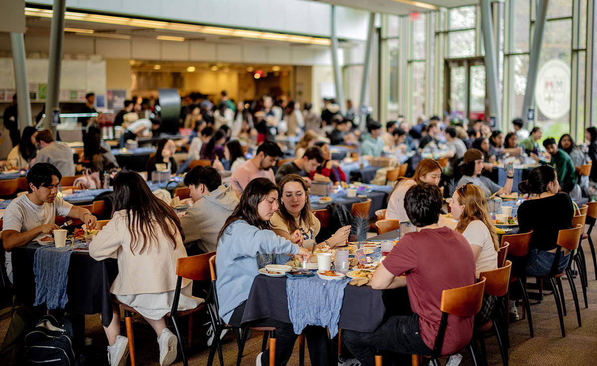Dozens of students around tables in a dining room
