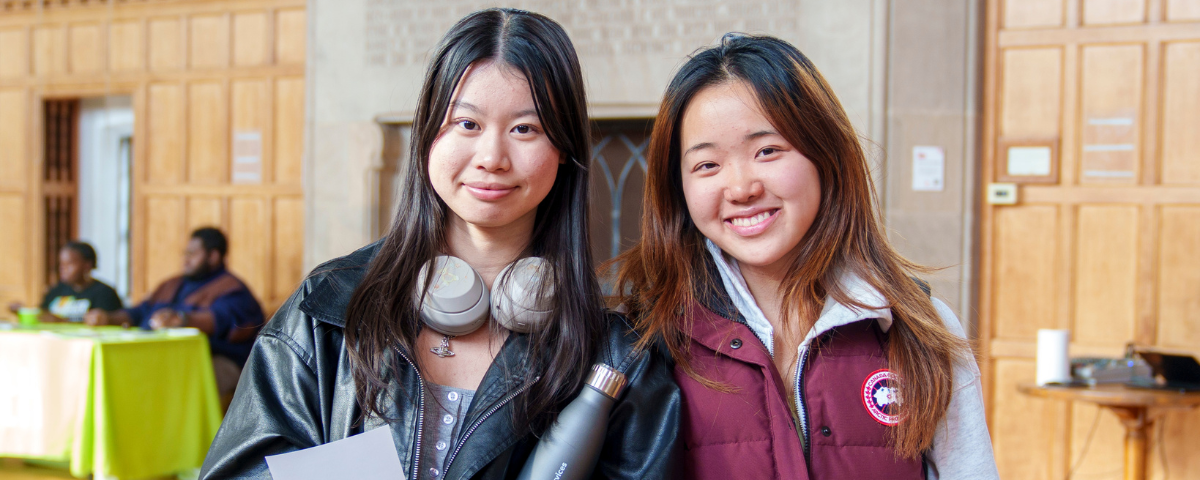 Two young women pose in Willard Straight Hall's Memorial Room