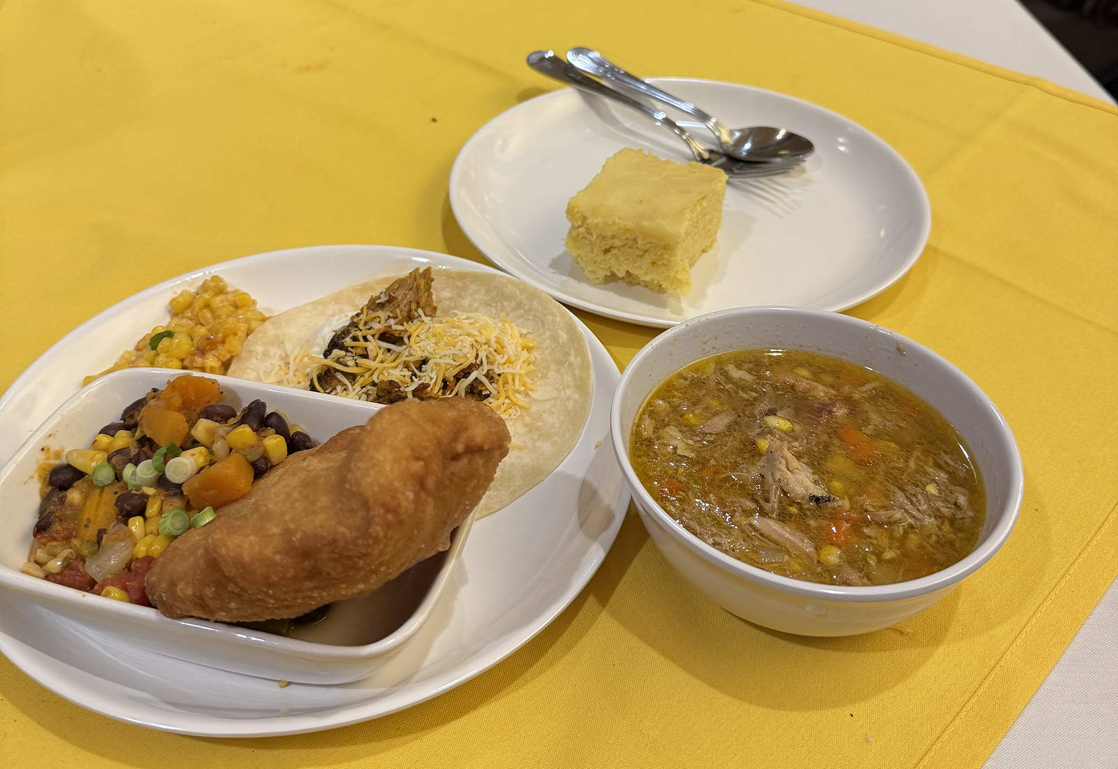 Three dishes of food on a yellow tablecloth