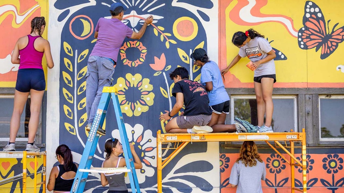 Students participate in a community paint event at Wildflower Farm in Enfield.