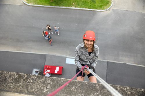 person rappelling down a wall