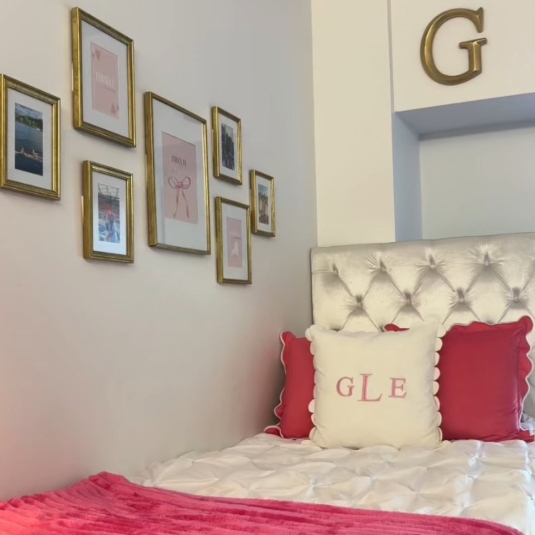 student room pictures on the wall, red and white linens on the bed