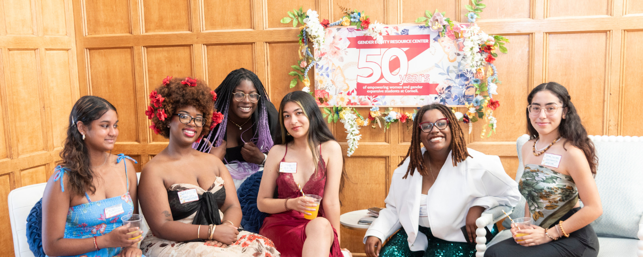 Women pose in front of 50th anniversary sign