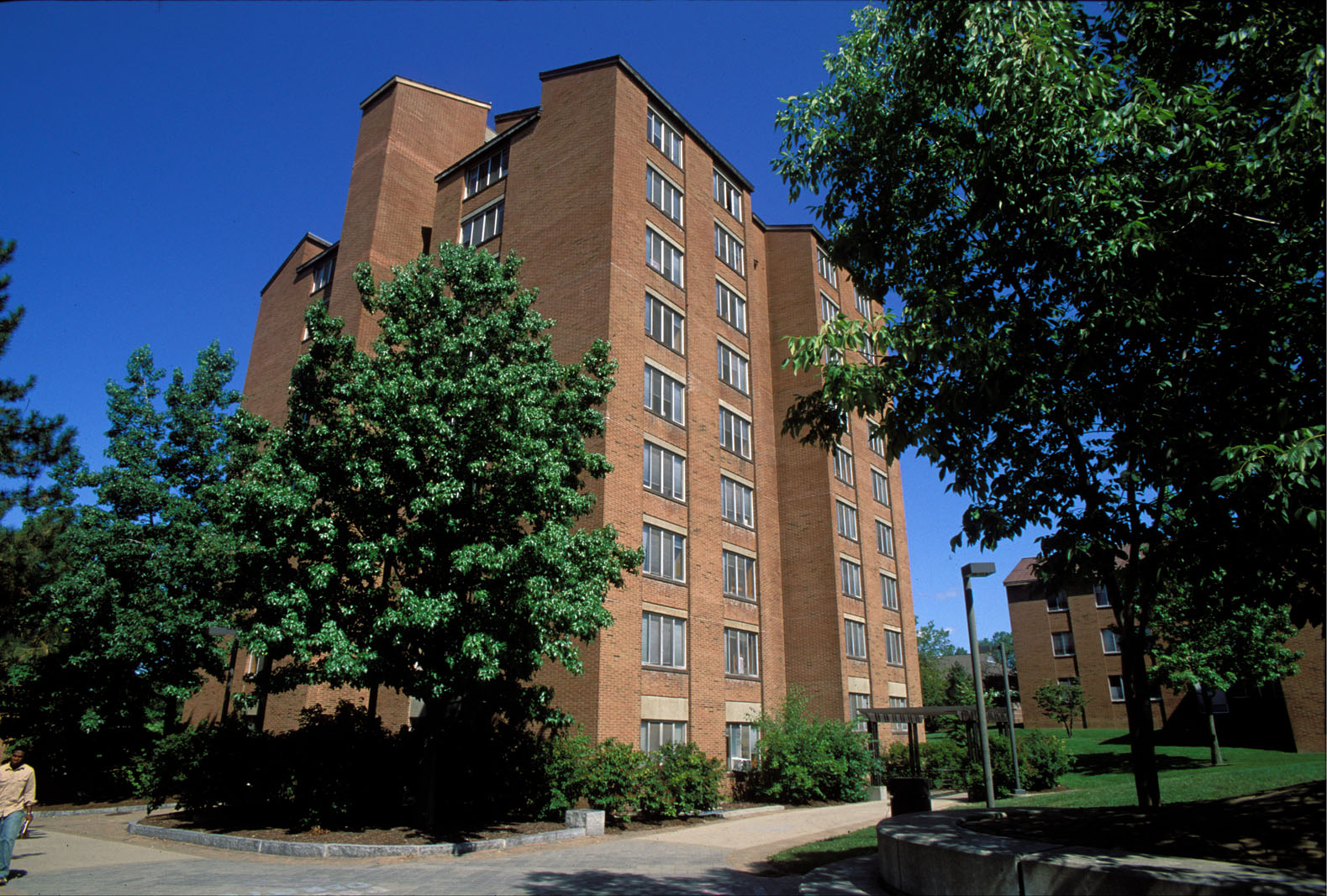 Exterior photo of High Rise 5 with green trees and bushes around it on a sunny day with a blue sky