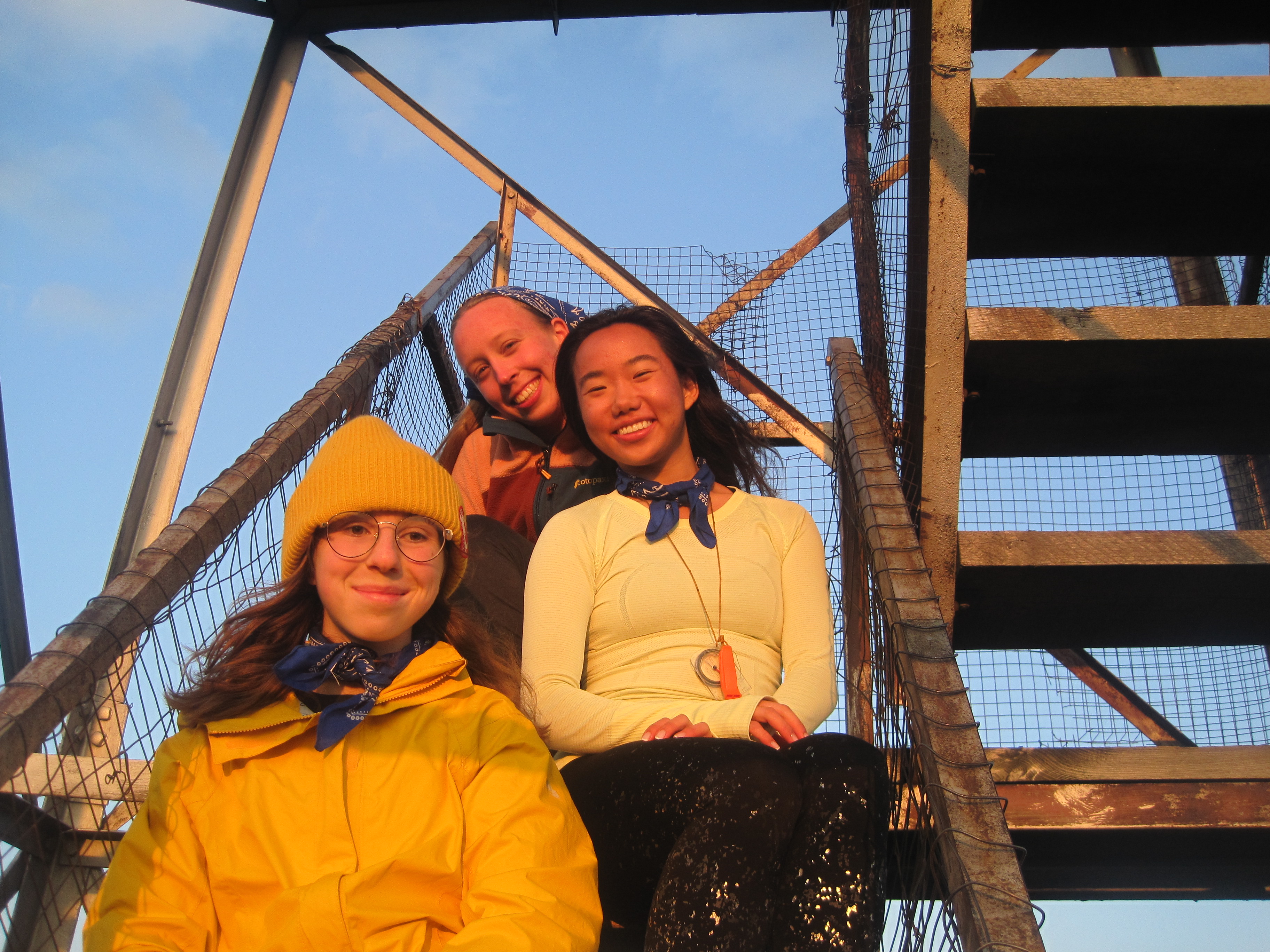 Three Odyssey trippers sit on a fire tower in the Catskills.