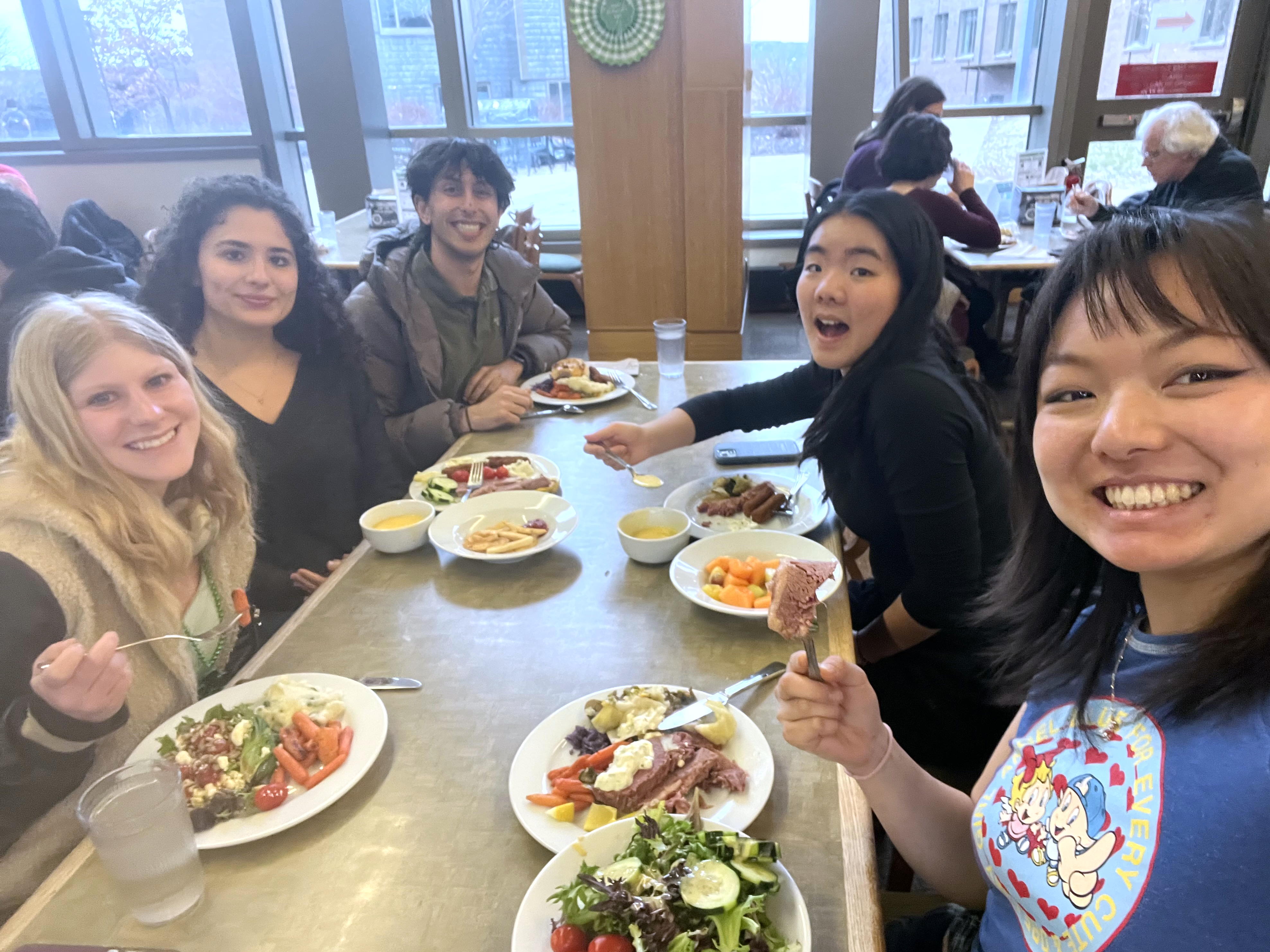 People sit around a table with plates of food