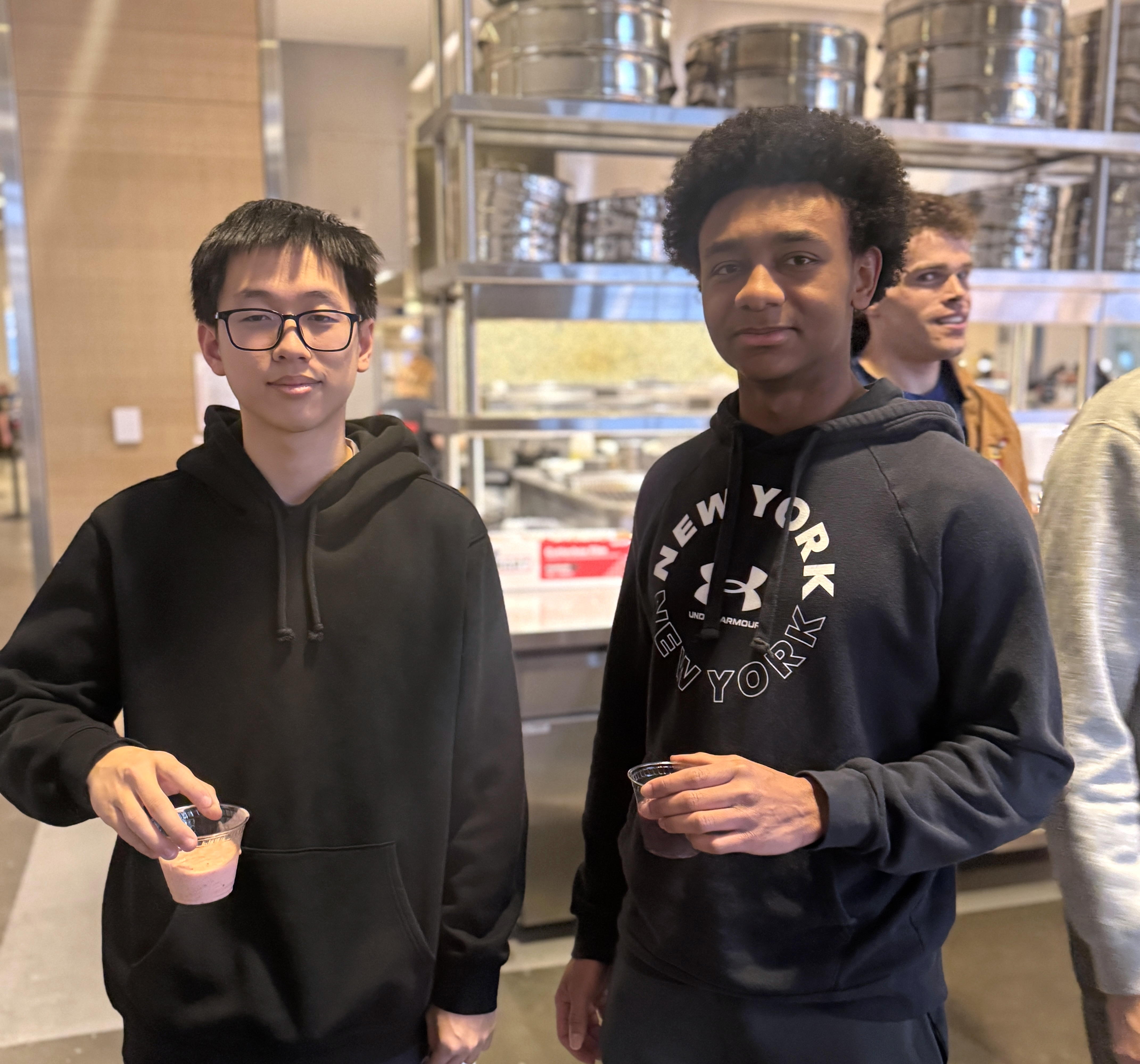 Students stand holding smoothie sample cups