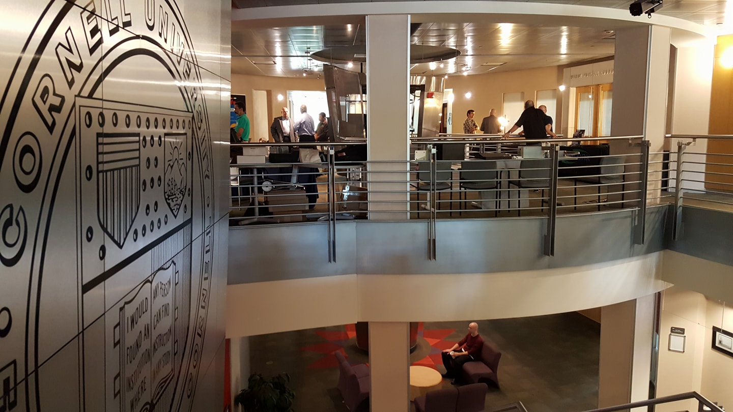 Image of the second floor circulation area where the Cornell Seal is shown on the silver wall.