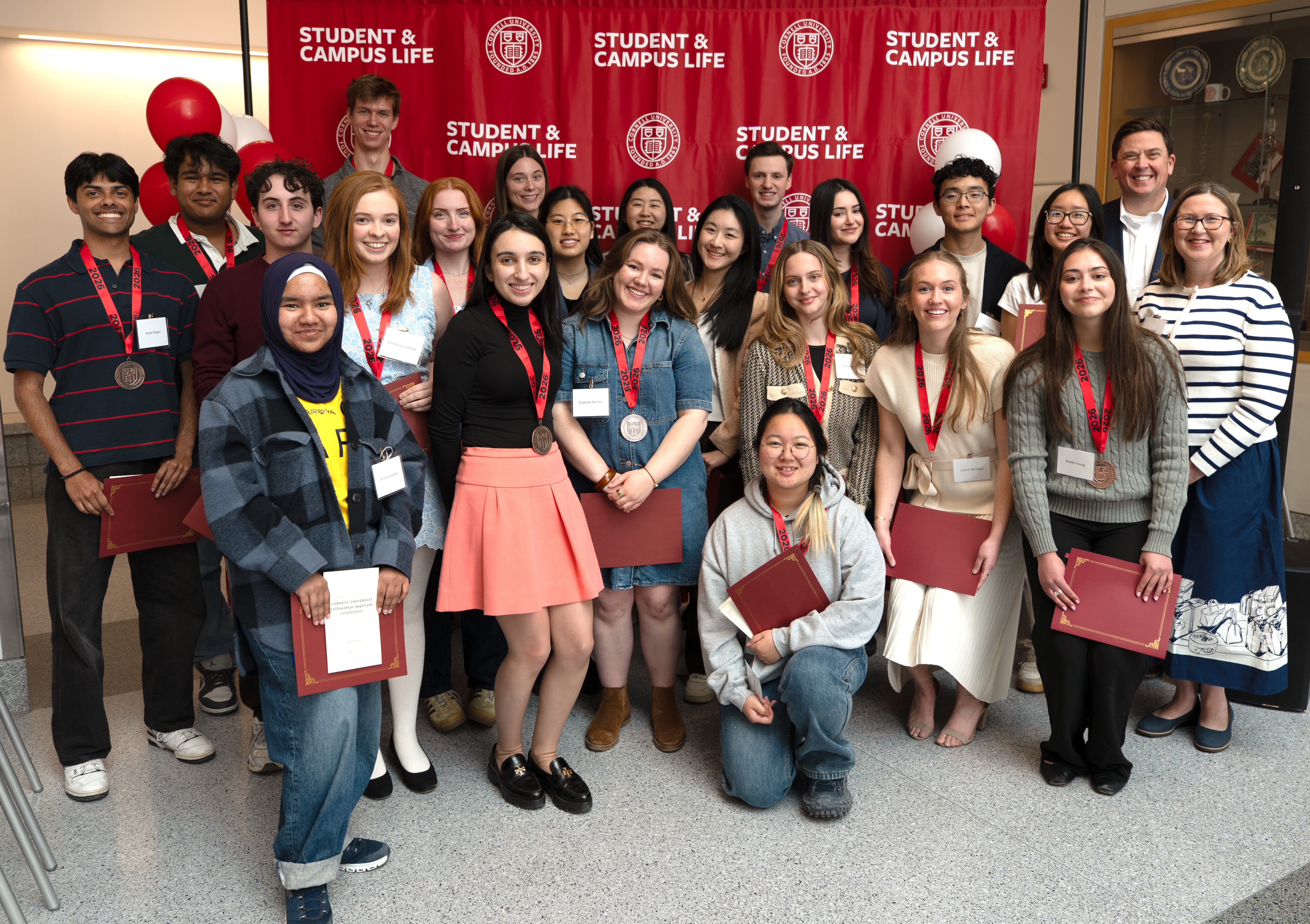 Cornell students and staff pose together with medals and certificates at a Student & Campus Life recognition event.