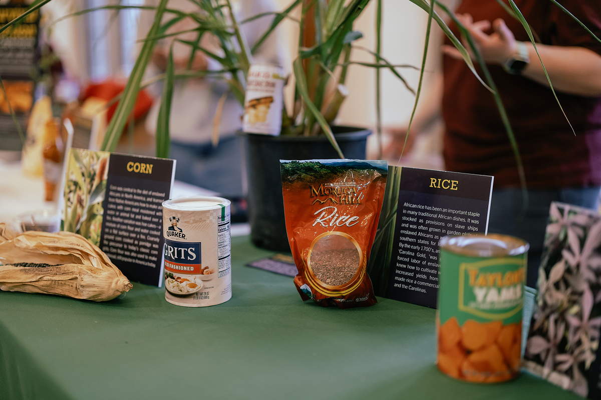 Containers of grits, rice, and yams on a display table
