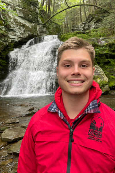 Trevor in red rain jacket near waterfall
