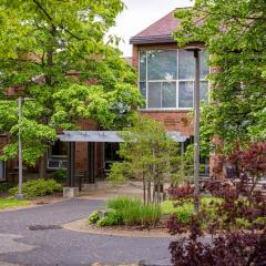 spring foliage outside a brick building with the name Ujamaa on the side