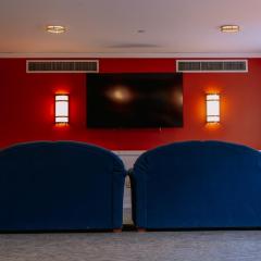 Lounge space in Clara Dickson Hall with red walls, two couches, and a television mounted on the wall