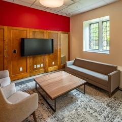 A lounge with a couch, two lounge chairs, a coffee table, and a tv.