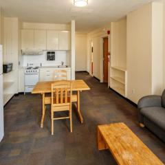 living room and kitchen with a couch, coffee table, cabinets, stove, microwave, fridge, and a table and chairs.