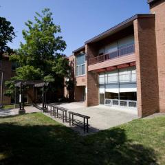 exterior of a brick building with treens and green grass