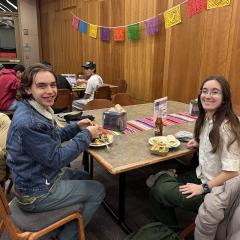 Two people at a dining room table with smiling faces turned toward us