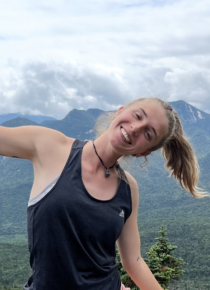 Sav outside with mountain in the background