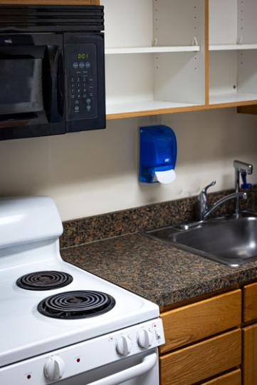 Low Rise kitchen with stove, sink, and empty cupboards