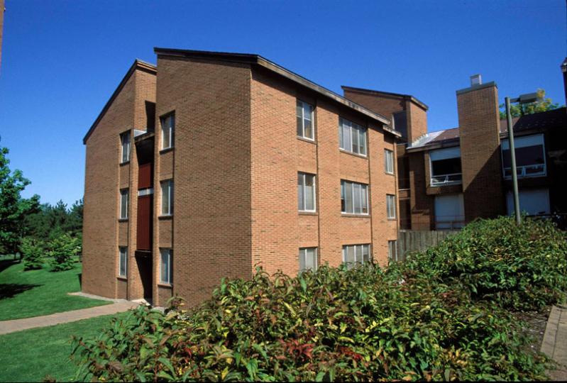 Low Rise brick building with blue sky and green grass and trees