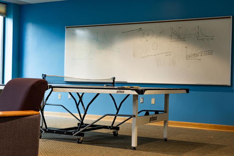 ping pong table in a blue room with a whiteboard