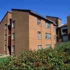 Low Rise brick building with blue sky and green grass and trees