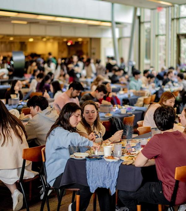 Dozens of students around tables in a dining room