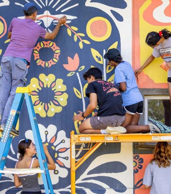 Students participate in a community paint event at Wildflower Farm in Enfield.