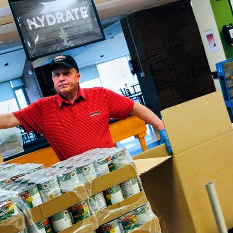 Tommy LaLonde, a cook at Robert Purcell Marketplace Eatery, boxes up food donations.