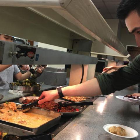 Student taking food from serving line