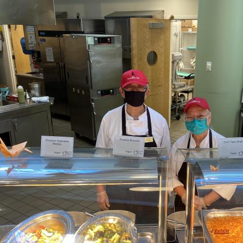 Dining staff wearing masks behind a service counter