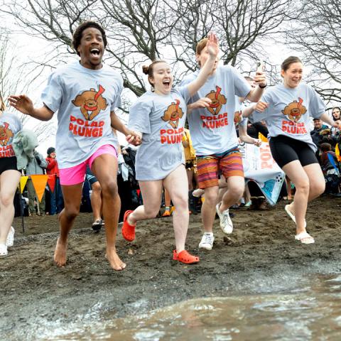 Four Cornell students run into the water