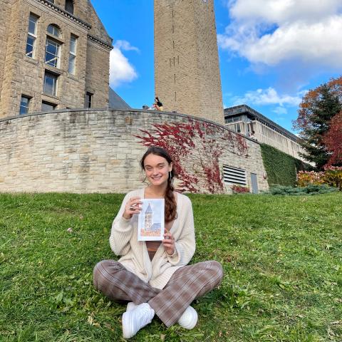 Elmore holds up a drawing of the McGraw Tower in front of McGraw Tower