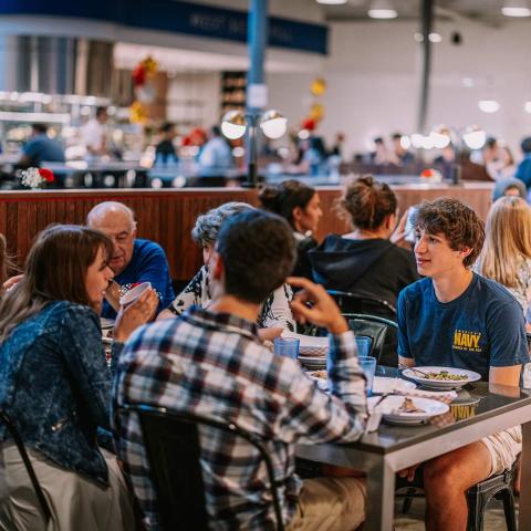 A table of diners inside a campus dining room